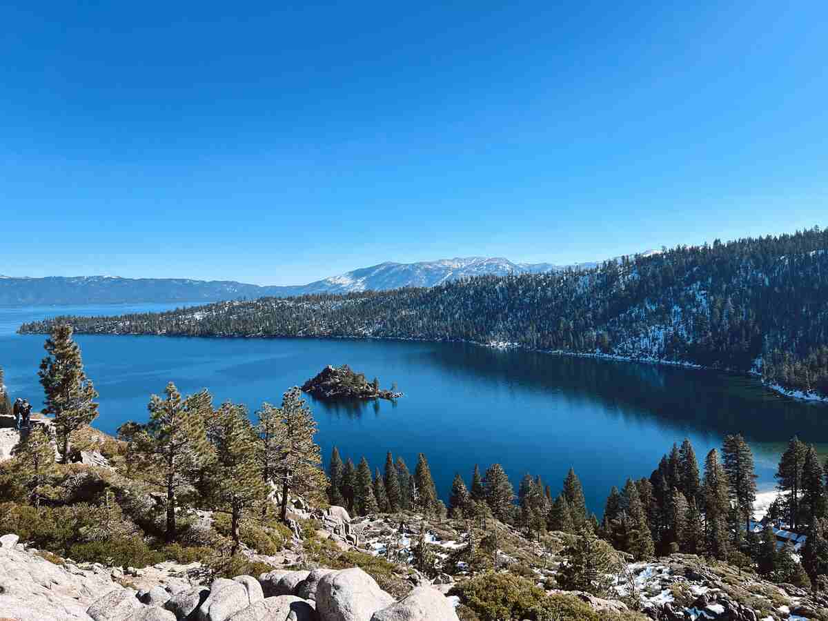 Lake Tahoe's crystal-clear blue waters with snow-capped Sierra Nevada mountains